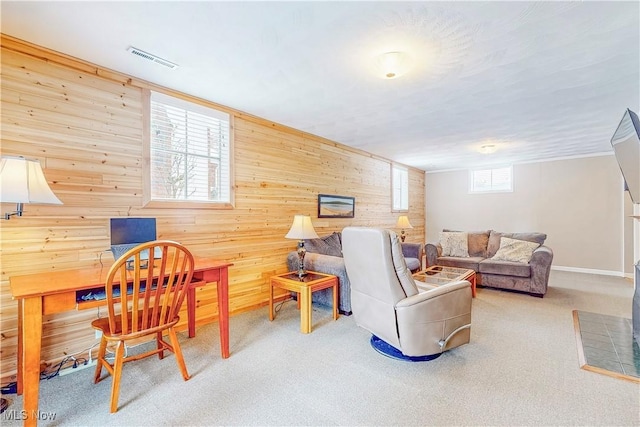 living area featuring wooden walls, carpet flooring, and visible vents