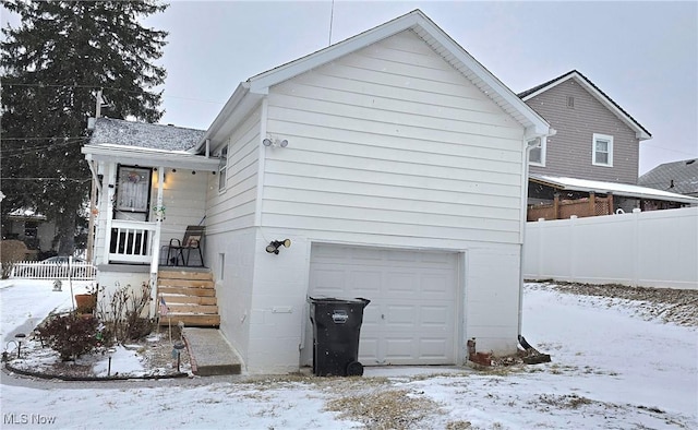 view of front of property featuring a garage and fence