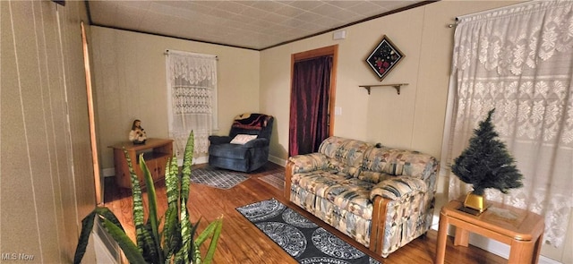 sitting room with wood finished floors and crown molding