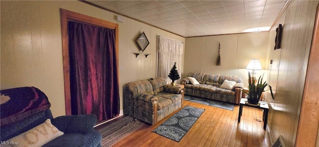 living area featuring ornamental molding, wood finished floors, and a decorative wall