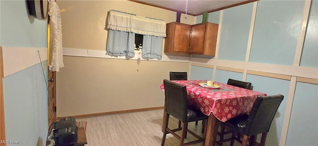 dining space featuring light wood finished floors and ornamental molding