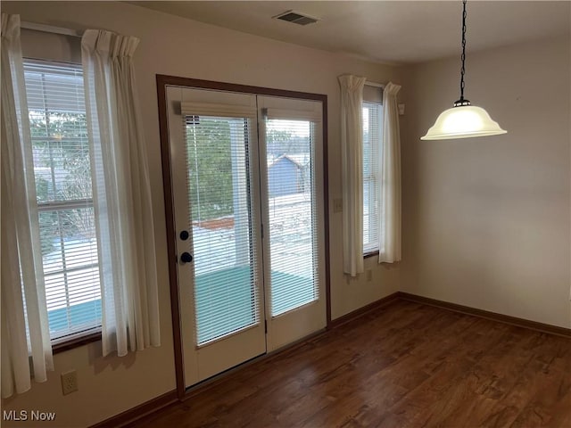 doorway to outside with dark wood finished floors, visible vents, and baseboards