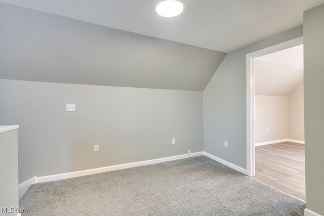 bonus room featuring lofted ceiling, baseboards, and carpet flooring