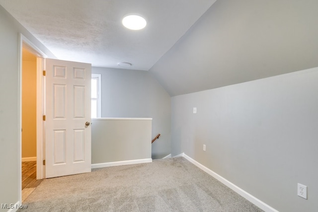 bonus room with light carpet, baseboards, and lofted ceiling