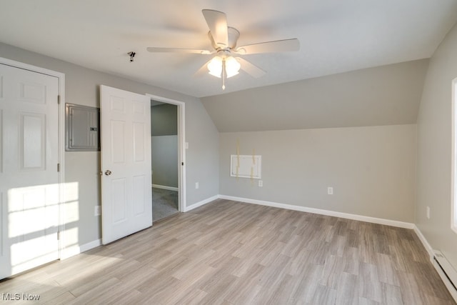 bonus room with a baseboard heating unit, baseboards, electric panel, and light wood finished floors