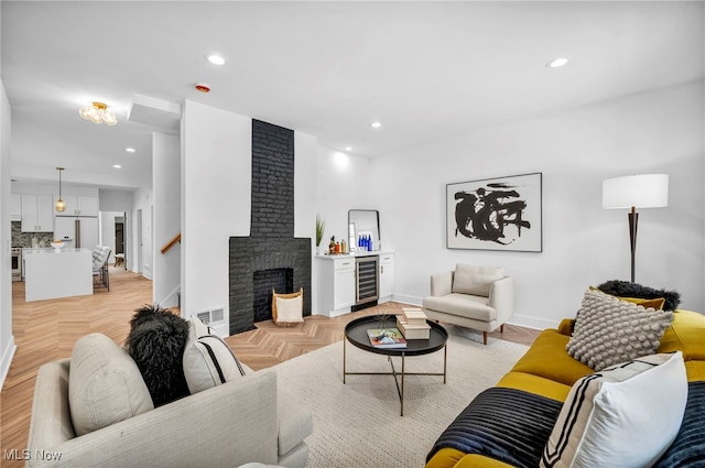 living room with recessed lighting, beverage cooler, visible vents, baseboards, and a brick fireplace