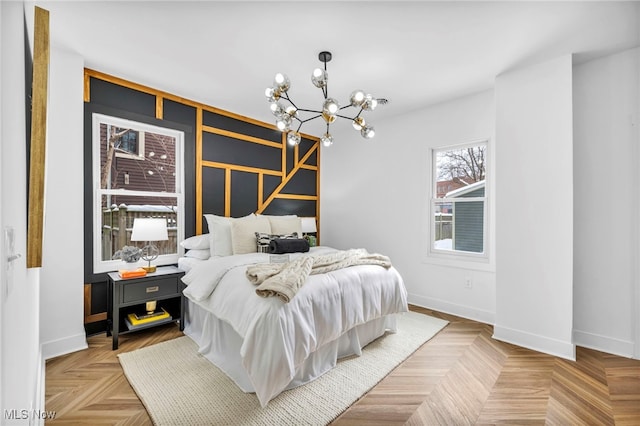 bedroom with baseboards and an inviting chandelier