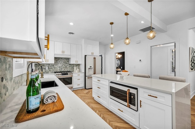 kitchen featuring light countertops, high end appliances, and white cabinets