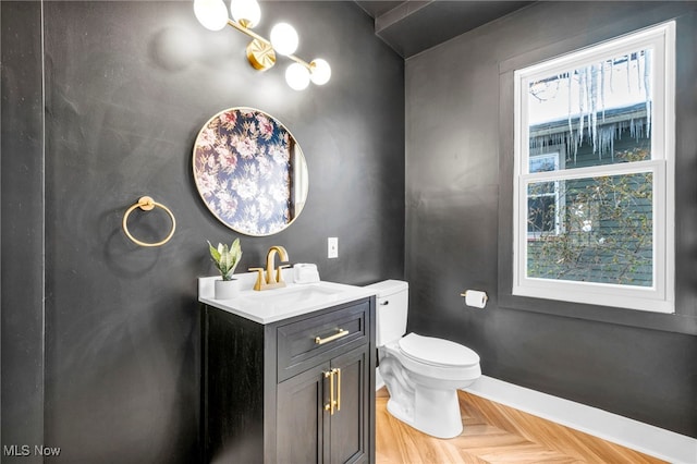 bathroom featuring toilet, vanity, and baseboards