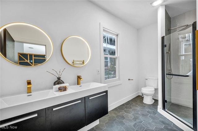 full bath featuring double vanity, a sink, toilet, and a shower stall