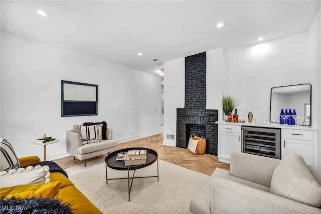 living area with recessed lighting, beverage cooler, visible vents, a brick fireplace, and a dry bar