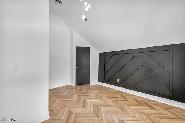 additional living space featuring lofted ceiling and visible vents