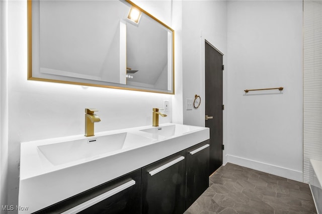 bathroom with a sink, baseboards, and double vanity