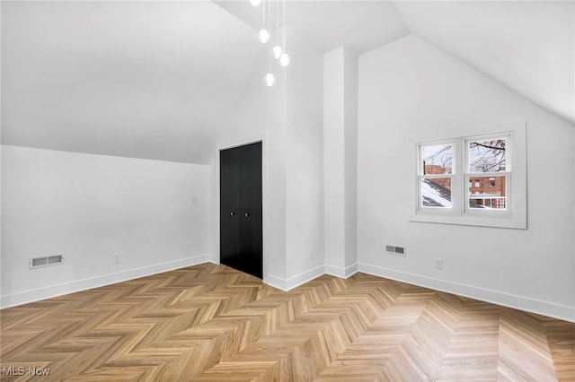 additional living space featuring high vaulted ceiling, baseboards, and visible vents