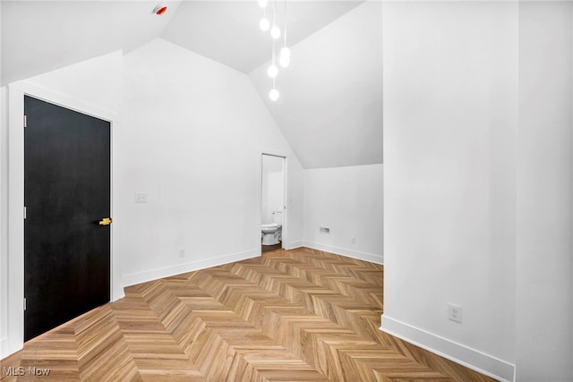 additional living space featuring lofted ceiling and baseboards