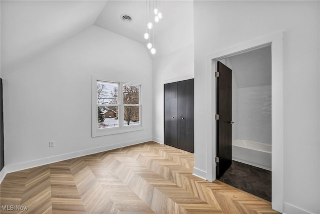 unfurnished bedroom featuring high vaulted ceiling, a closet, visible vents, and baseboards