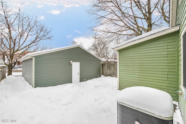 snow covered garage with fence