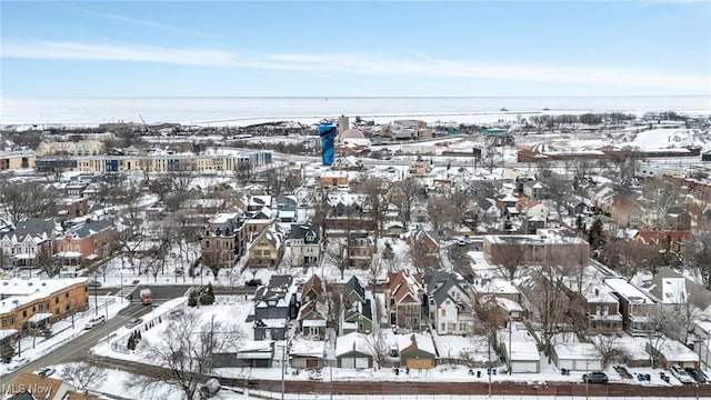 snowy aerial view with a water view and a residential view