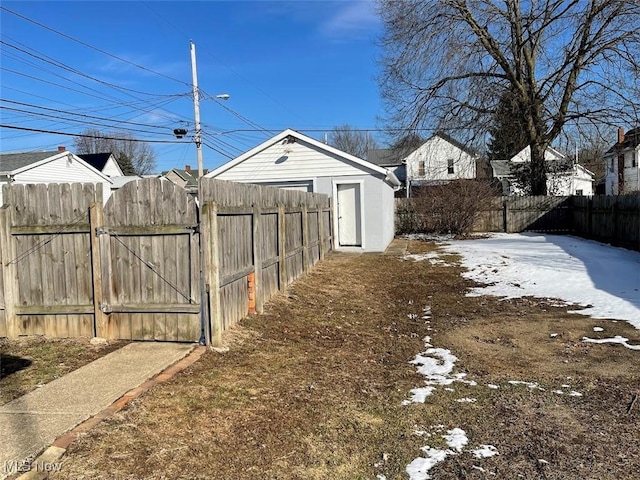 yard layered in snow featuring a gate and fence