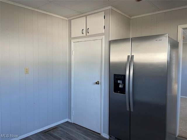 kitchen featuring dark wood-style flooring, stainless steel refrigerator with ice dispenser, visible vents, and crown molding