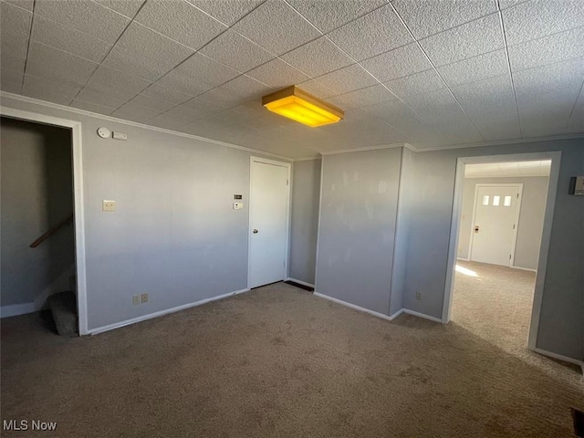 unfurnished room with carpet, baseboards, and crown molding