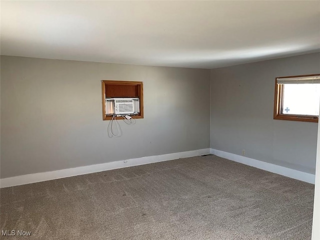 spare room with cooling unit, carpet flooring, and baseboards