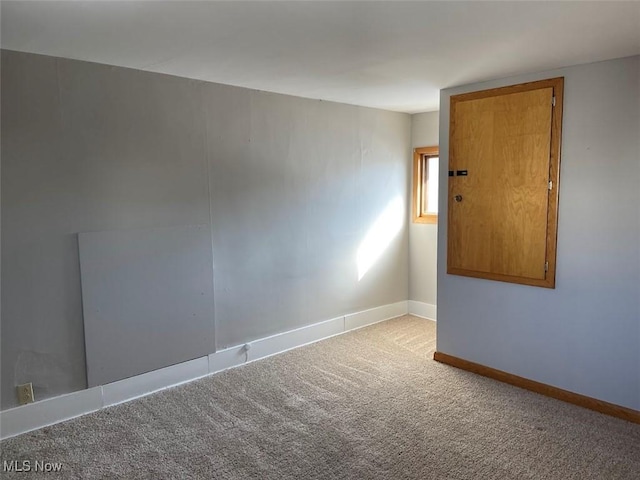 unfurnished room with light carpet and baseboards