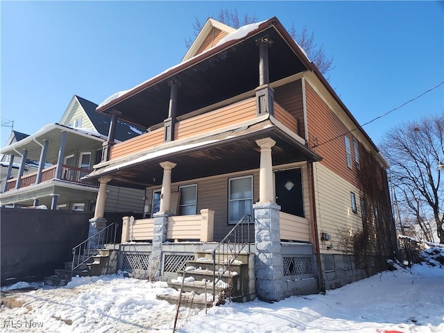 view of front of home with a porch, stairway, and a balcony