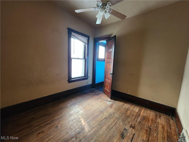 unfurnished bedroom featuring a ceiling fan, baseboards, and hardwood / wood-style floors