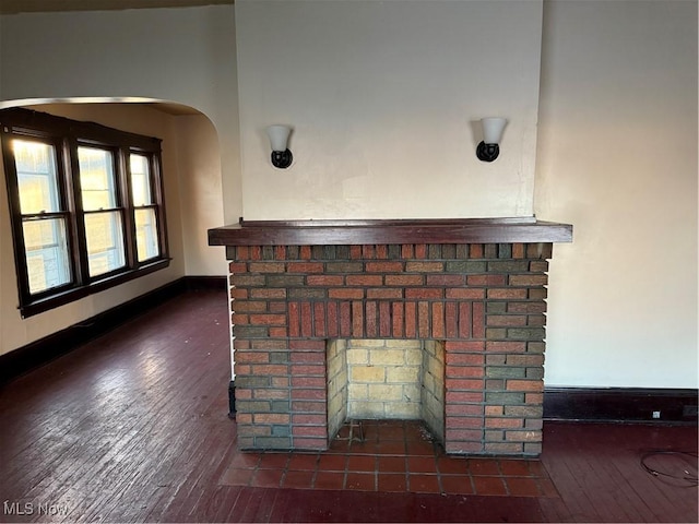 interior space featuring a fireplace, wood finished floors, and baseboards