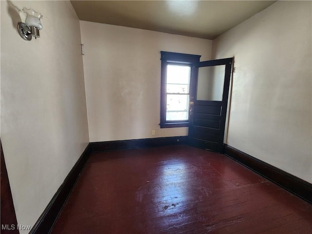 unfurnished room featuring baseboards and hardwood / wood-style floors