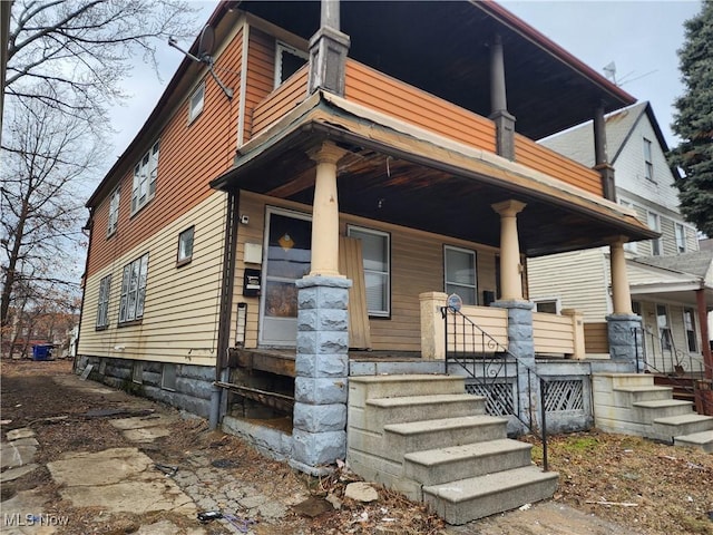 view of front of home featuring covered porch and a balcony