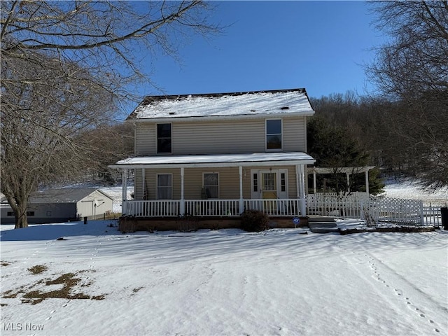 farmhouse-style home with fence and a porch