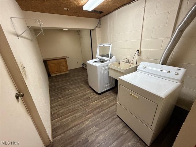 clothes washing area featuring laundry area, dark wood-style flooring, a sink, washer and dryer, and concrete block wall