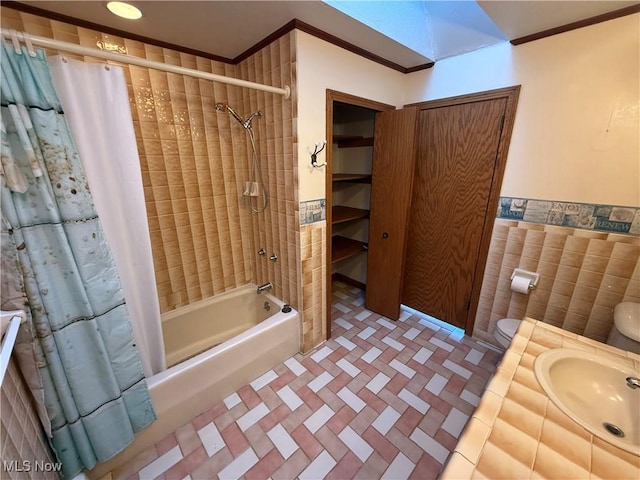 full bath with shower / tub combo, toilet, a sink, crown molding, and tile walls