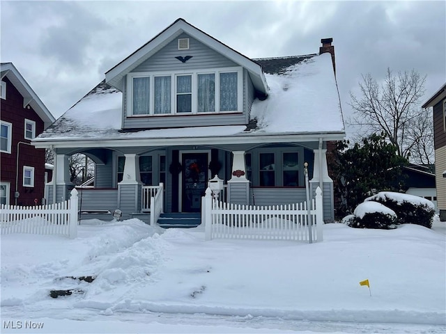 view of front of home with covered porch and a chimney