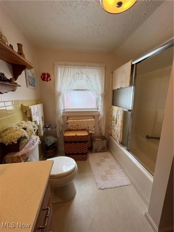 full bathroom featuring enclosed tub / shower combo, a textured ceiling, vanity, and toilet