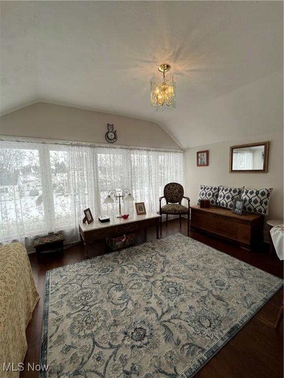 living room featuring lofted ceiling, a chandelier, and wood finished floors