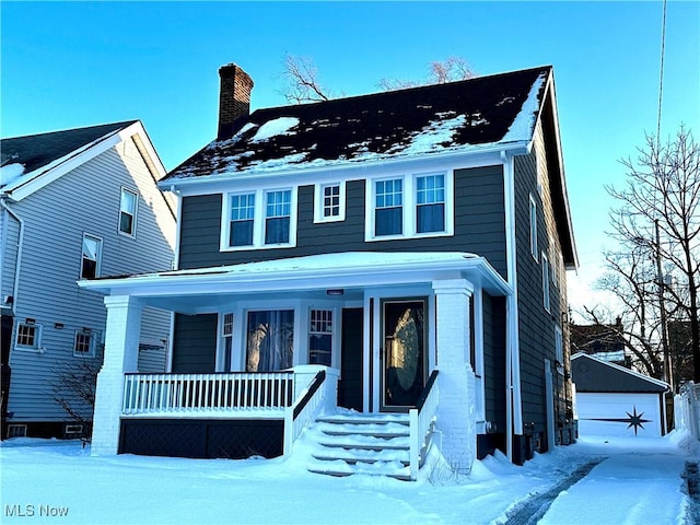 traditional style home with a porch, an outdoor structure, and a chimney