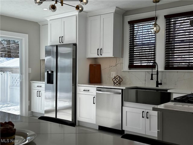 kitchen with white cabinetry, appliances with stainless steel finishes, light countertops, and a sink