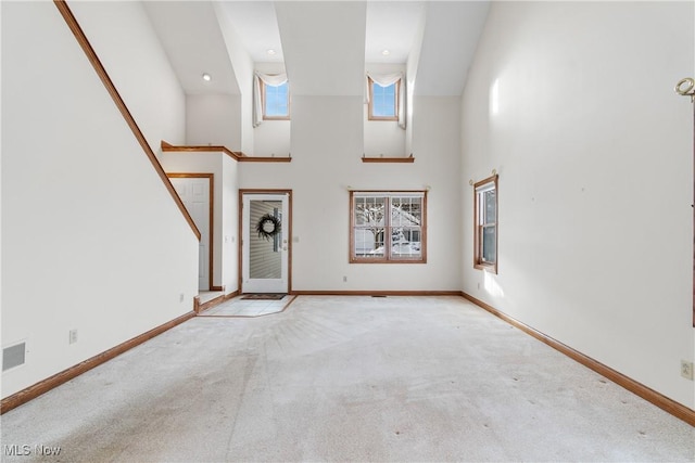 foyer with light colored carpet, baseboards, a high ceiling, and recessed lighting