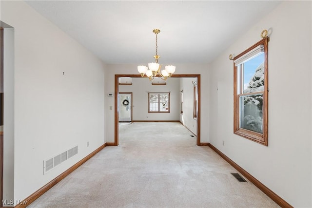 interior space featuring baseboards, visible vents, a notable chandelier, and light colored carpet