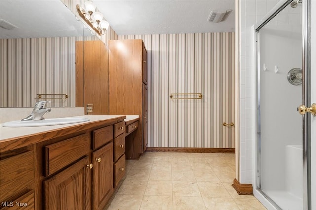 full bath featuring visible vents, a shower stall, vanity, baseboards, and wallpapered walls