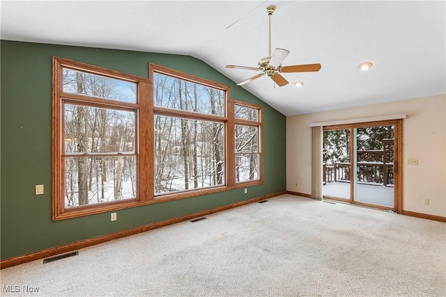 spare room with lofted ceiling, carpet floors, visible vents, and baseboards