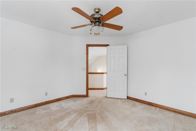 empty room featuring light carpet, ceiling fan, and baseboards