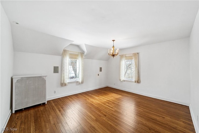 bonus room with radiator heating unit, baseboards, a wealth of natural light, and wood finished floors