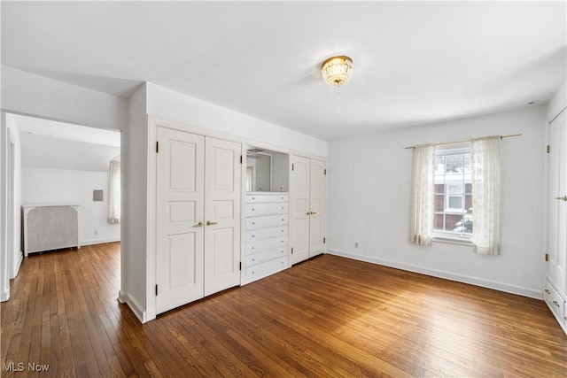 unfurnished bedroom featuring wood finished floors and baseboards