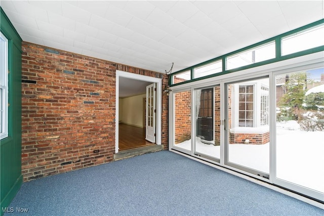 spare room with carpet and brick wall