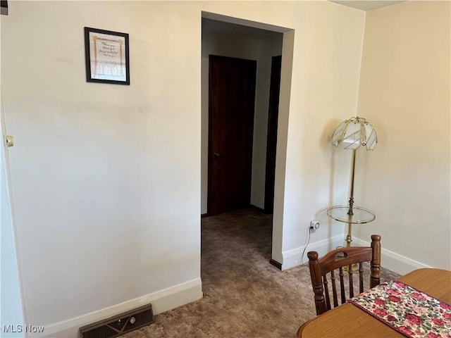 interior space with dark colored carpet, visible vents, and baseboards