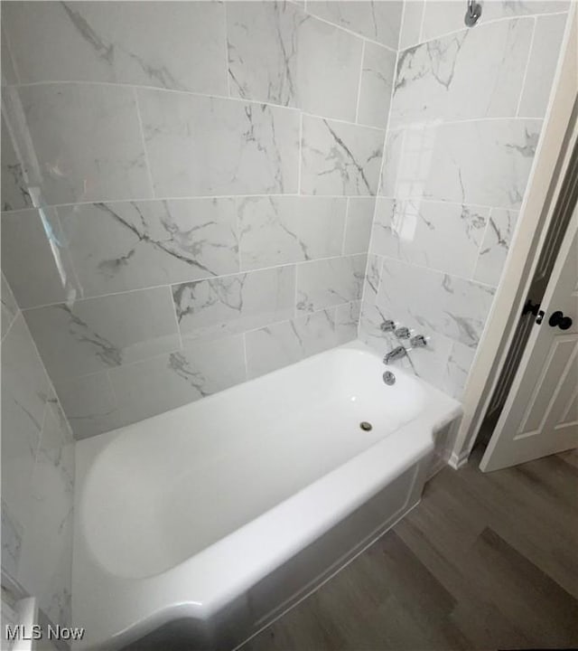 bathroom with shower / bathing tub combination and wood finished floors